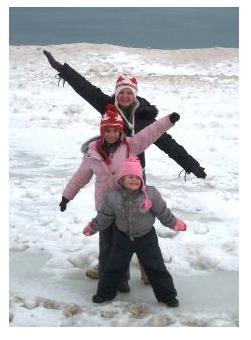 Three Children playing in the snow in winter on the beach at Port Stanley, Ontario, Canada