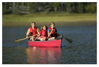 family canoeing in an Ontario lake in red canoe