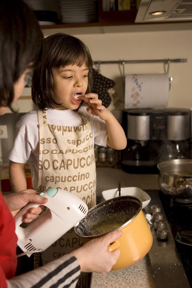 happy homeschooled child baking at home with mother