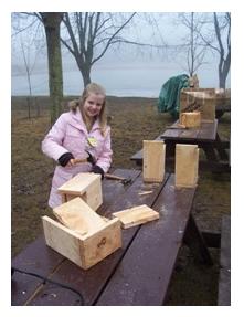 Child outdoors making a birdhouse at Springwater Conservation Area, Orwell, Ontario